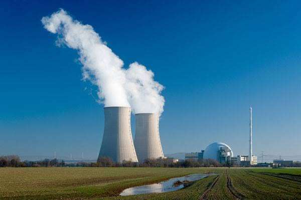 Nuclear power station with cooling towers releasing water vapour